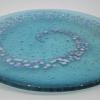 Transparent Teal Glass plate infused with reactive glass chunks, formed into a spiral.